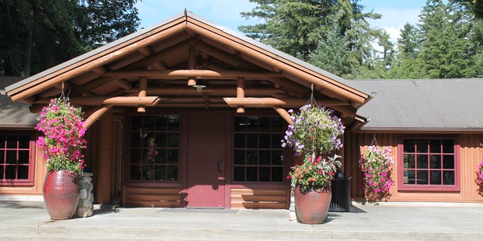 Front entrance to Beaver Lake Lodge with a giant flower-filled pot on each side of entrance.